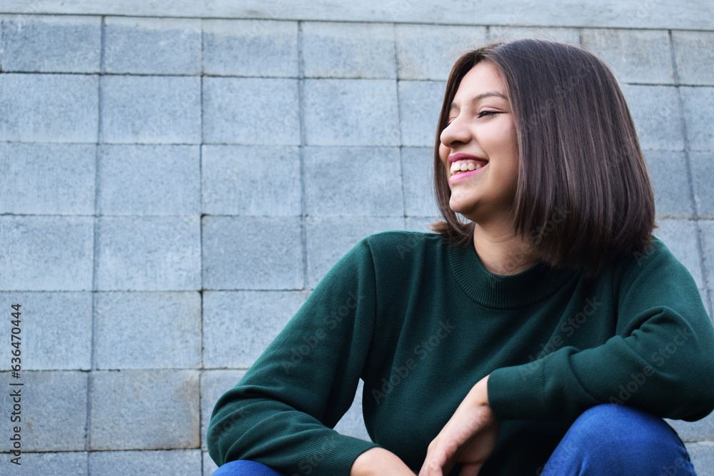 Chica joven sonriente, mientras pasa el rato al aire libre.